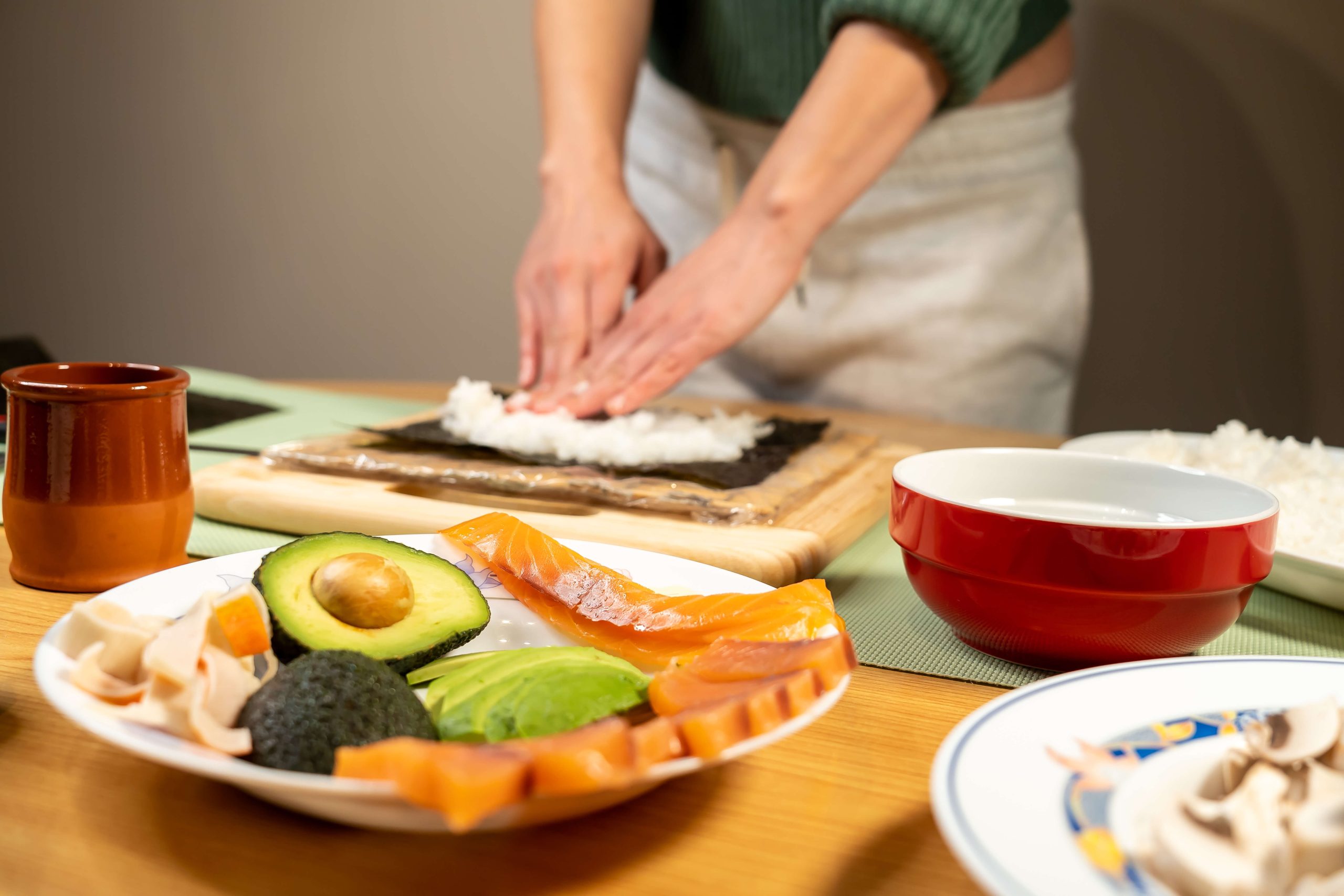 Close-up of hands preparing sushi ingredients