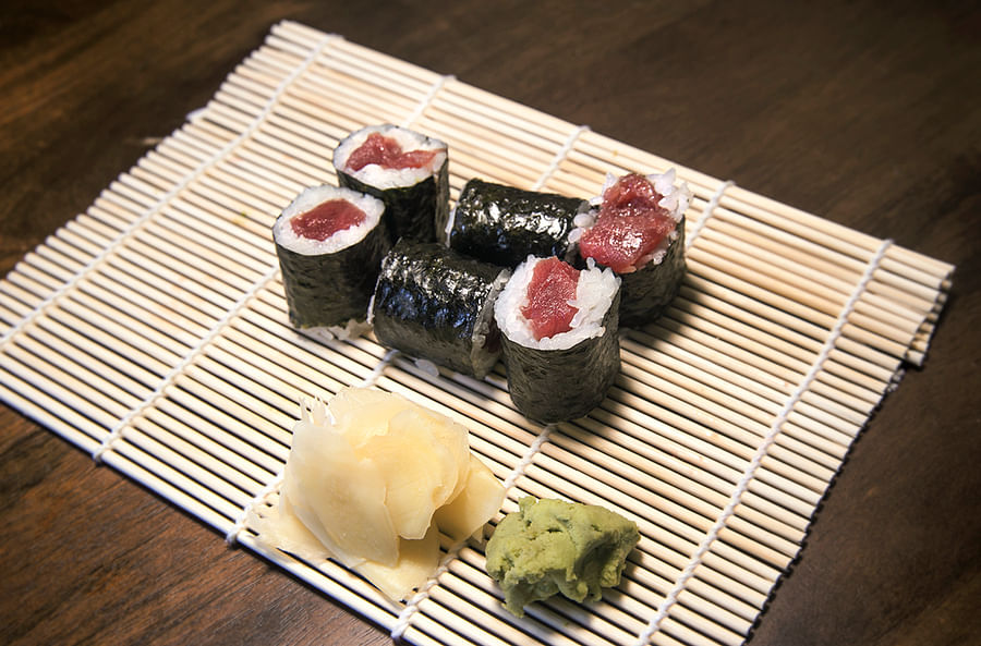 Close-up image of a piece of Toro sushi on a traditional sushi mat