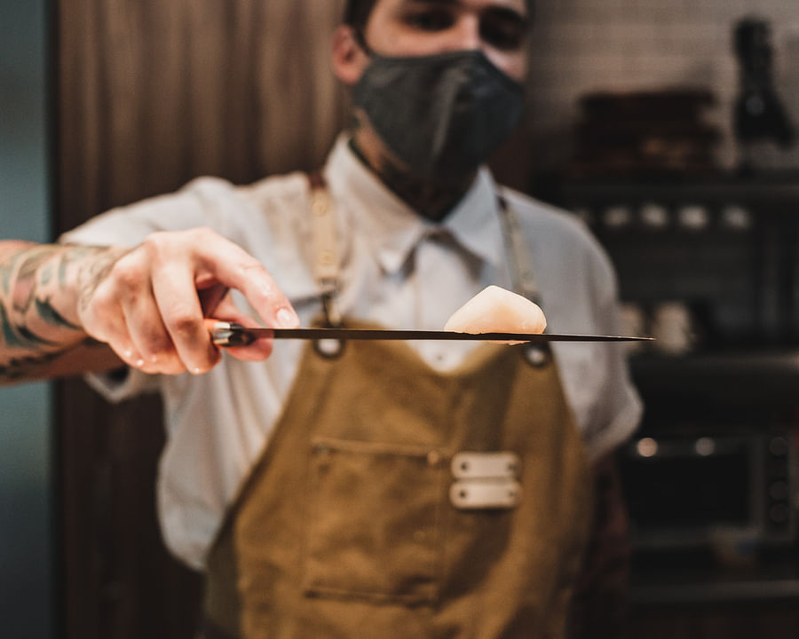 Japanese sushi chef meticulously preparing sushi at a traditional sushi bar