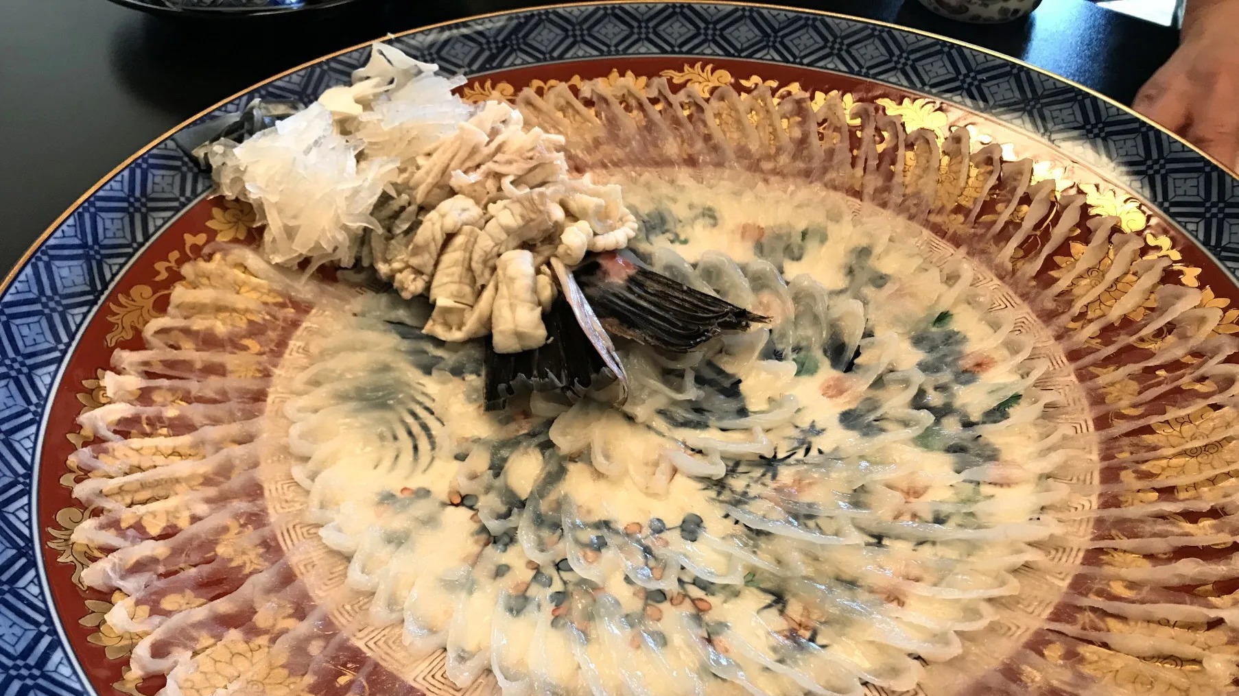 Sushi chef meticulously preparing Fugu sushi roll